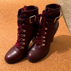 Burgundy high heel combat boots.